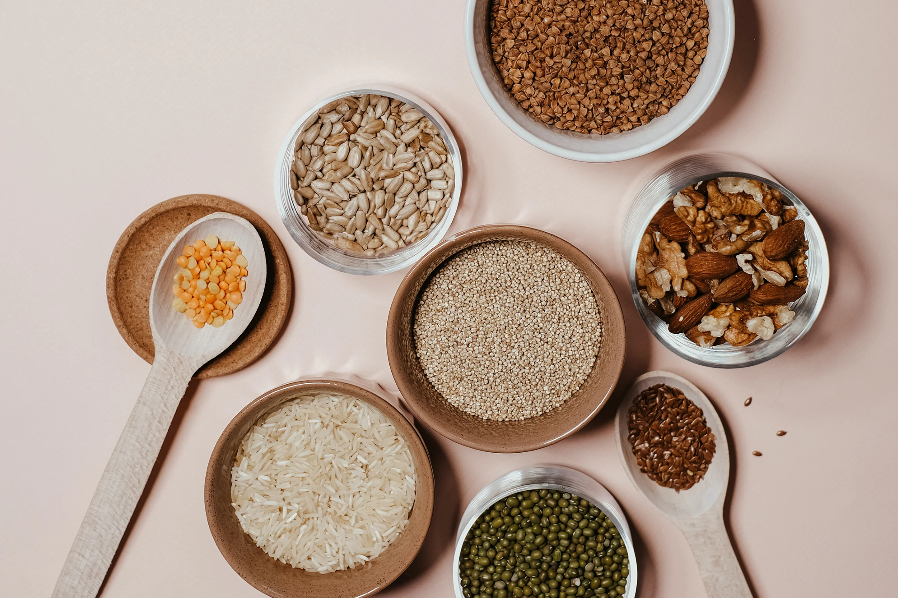 small bowls of rice, seeds, nuts, and lentils